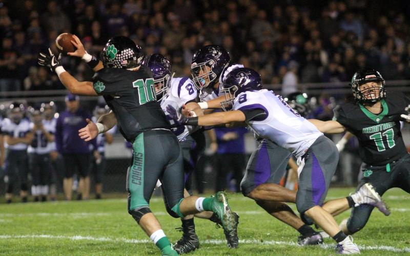 Mitchell High School juniors Cole Sparks (No. 89), Caius Peterson (No. 2) and Ty Sparks (No. 9) converge on Mountain Heritage quarterback Callin Randolph Friday, Oct. 18 during the Mountaineers' 14-6 loss to the Cougars in Burnsville. (MNJ photo/Cory Spiers)