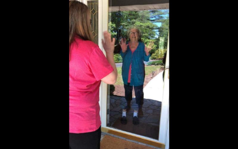 Lillian Benton, a patient involved with the Community Health Program in Mitchell County, waves to her community health worker. Photo courtesy of MCHP.