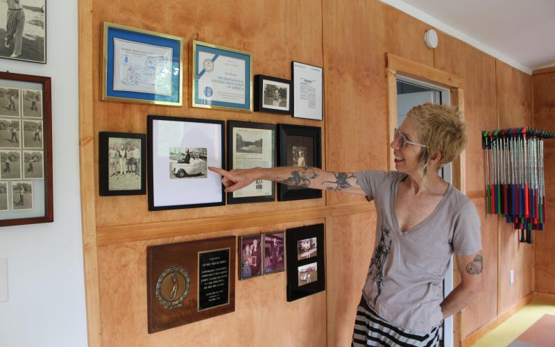 Kim Oberhammer points to photos and memorabilia of her grandfather, Victor.