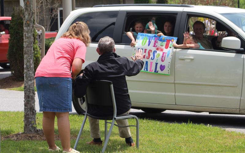 Mitchell House Resident Waves at Family During Parade