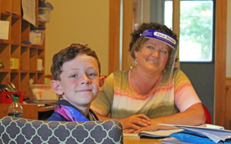 Michelle Gouge tutors Ben Pargh while wearing a face shield at Camp Spring Creek in Bakersville. The camp, like others in the area, has had to accomodate restrictions and guidelines regarding the ongoing COVID-19 pandemic. (MNJ photo/ Juliana Walker)