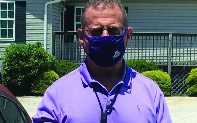 Mitchell County Sheriff Donald Street dons his mask as he prepares to head out on patrol. Street said masks are not a political issue and said he plans to wear one if it helps protect others. He encourages the public to do the same. (Submitted photo)