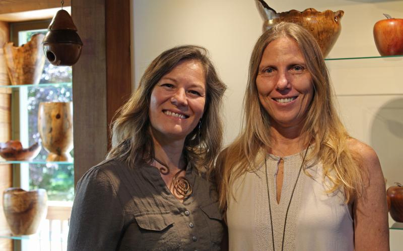 Sweetgrass Artisan Mercantile co-owners Jessica Charapata (left) and Melissa Andersen (right) smile and pose for a photo inside of their new gallery in Bakersville. (MNJ photo/Juliana Walker)