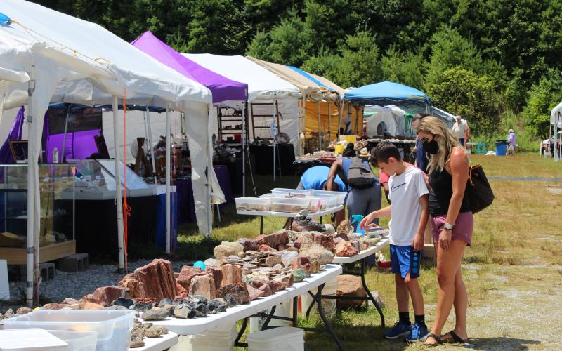 Guests at the Grassy Creek Gem and Mineral Show browse the wares of one of the show’s vendors Friday, July 31. (MNJ photo/Juliana Walker)