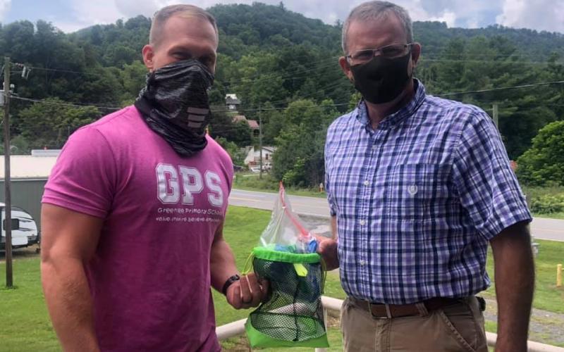 Greenlee Primary Principal Jason Hall and Gouge Elementary Principal Colby Calhoun hold one of their newly-created playground bags which are designed to allow students to play safaly amid the pandemic. (Photo by Mitchell County Schools)