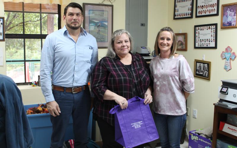 Mitchell County Department of Social Services Program Director Shawn Block, Adoption and Licensing Worker Donna Davis and Hollifield’s Christian Child Care Center Director Donna Woody pose for a photo with one of the purple tote bags the children’s center donated to DSS. The tote bags will go to children in DSS custody so they don’t have to move their belongings in trash bags when they move to a new home. (MNJ photo/Juliana Walker)