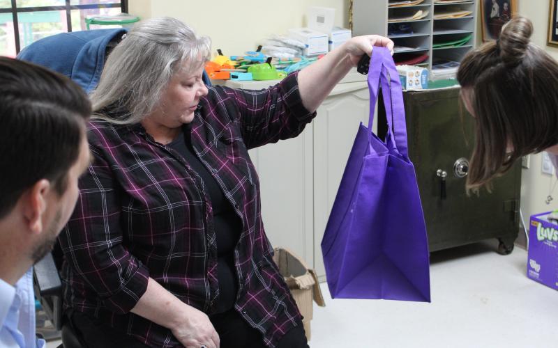 DSS Adoption and Licensing Worker Donna Davis gets at closer look at one of the bags that Hollifield’s Christian Child Care Center donated to the department.  (MNJ photo/Juliana Walker)
