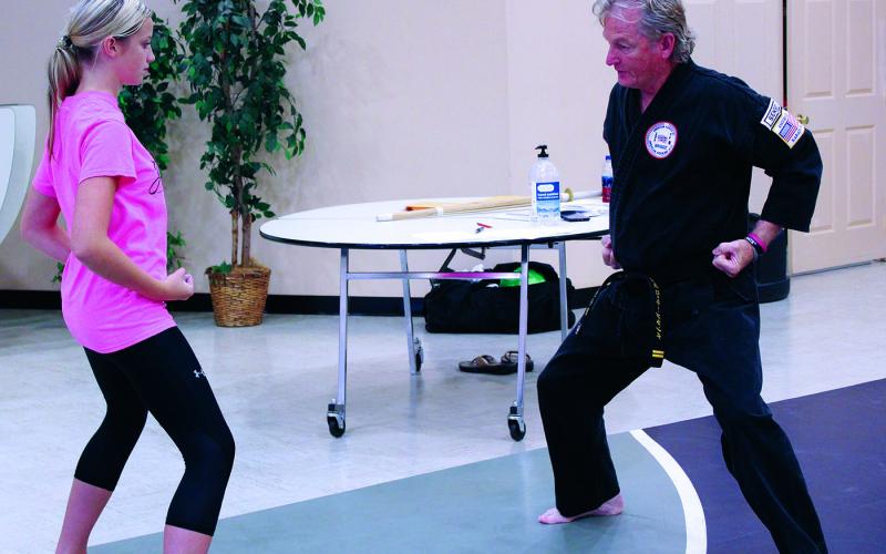 Spruce Pine First Baptist Church Pastor and Karate Instructor Rocky Branch demonstrates proper technique as Kayleigh Hollifield watches and tries her best to replicate it. Branch teaches a karate class at the church twice per week. The class is open to all ages and skill levels. Classes cost $1 and consist of instruction from Branch with help from other experienced martial artists. (MNJ photo/Cory Spiers)