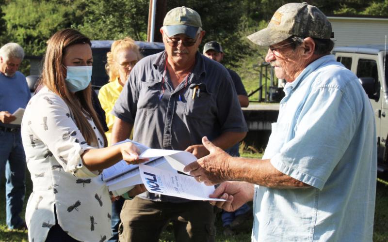 Halley Burleson hands out fliers to local residents at the special meeting Tuesday, Aug. 25. (MNJ Photo/Juliana Walker)
