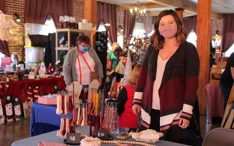 Mitchell County native Brittney King keeps watch over her booth at the Spruce Pine Southern Christmas Show on Saturday, Nov. 28 at the Cross Street Commerce Center. King, who heard about the show from a fellow craftsman, was one of 40 vendors set up at the show. (MNJ photo/Juliana Walker)