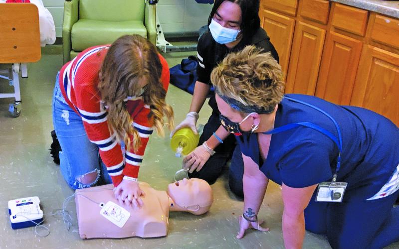 Shannon Tipton of Hospice, Palliative and CAP of the Blue Ridge looks on as Mitchell High School students perform adult and infant CPR. Tipton helped 35 students earn their CPR certification through hands-on training and testing. (Submitted)