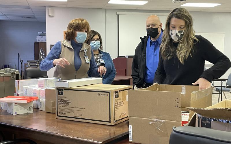 Neill, Hale and Vance look on as Mitchell County School Nurse Elizabeth Sparks unboxes and inspects some of the new Stop the Bleed kits. (MNJ Photo/Juliana Walker)