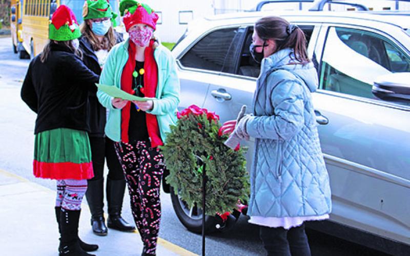 Alli McClellan of the Creative Clovers 4-H Club smiles under her face covering as she takes a letter to Santa delivered by car at Bowman Middle School on Saturday, Dec. 5. In addition to processing Santa letters and other duties, club members also sold Christmas ‘Neath the Roan T-shirts. (MNJ photo/Cory Spiers)