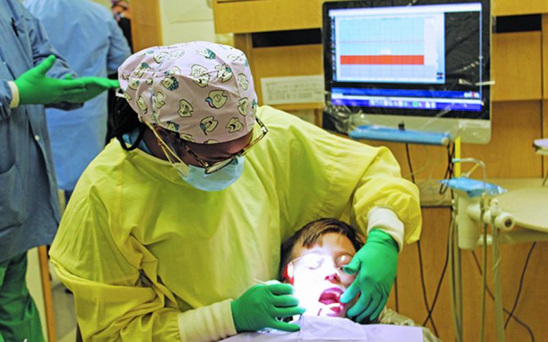 Vonstrika Jones gives 8-year-old Alexei Yoder a dental check with a mirror on Friday, Feb. 5. Jones and the rest of the staff at the East Carolina University School of Dental Medicine Community Service Learning Center of Spruce Pine performed free services during the annual Give Kids a Smile event. (MNJ photo/Cory Spiers)