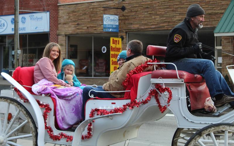 The Jones family smiles as they enjoy a carriage ride through downtown Spruce Pine on Saturday, Feb. 13. The rides were part of a promotion from the Mitchell Chamber of Commerce that encouraged folks to shop local. The Jones family consists of April, Brandon, Finley and Audrey. (MNJ photo/Juliana Walker)