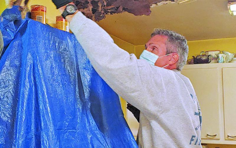 This past fall, volunteers from Spruce Pine United Methodist Church rallied to support a local senior with roof repairs. Volunteers restored the ceiling where water levels had caused damage. Pictured above repairing the ceiling is volunteer Mike Murphy. (Submitted photo)