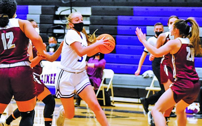 Senior guard Jill Pittman navigates the floor amid a trio of Owen defenders and looks for a friend to pass to during a home game on Wednesday, Feb. 3. Pittman and the Mountaineers blew out Owen and beat Mountain Heritage the next day to stay perfect. (Photo by Tessa Taylor)