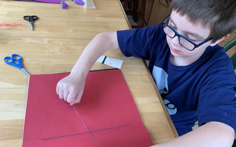 Ezra McClure, a student in Michelle Stafford’s third-grade class at Deyton Elementary, sews the pages of his moon journal. Students and teachers were forced to adapt to the new virtual format this year. (Submitted)