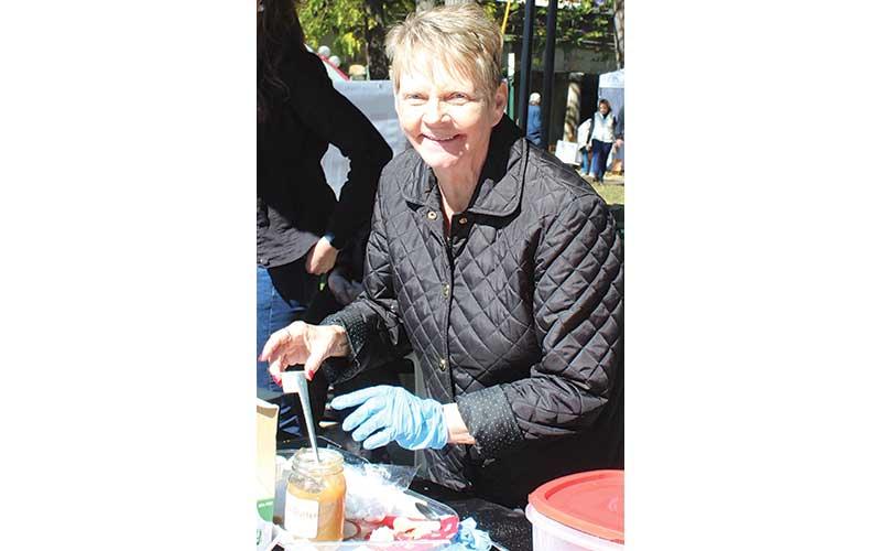 MNJ photo/Rachel Hoskins - Sue Ledford, a member of the Mitchell County Historical Society serves up samplings of apple butter with a smile during the Mountaineer &amp; Apple Butter Festival in Bakersville.