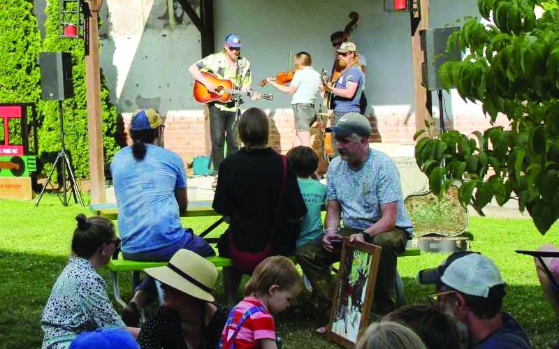MNJ Photo/Sarah Atkins. Marketgoers gather at the Pocket Park for live music from Jackson Grimm and The Bull Moose Party.