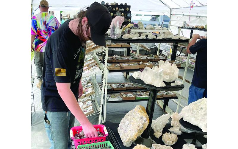 MNJ Photo/Mariel Williams. Schuyler Daugherty, 18, of Asheboro looks through a bin of polished stones at the Grassy Creek Mineral &amp; Gem Show. Daugherty was in town this past weekend visiting family. “I love coming here,” he said. “Now that I have my own money I plan on spending more than usual.”