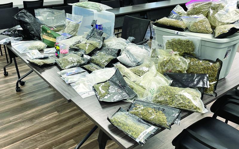 MNJ photo/Mariel Williams. The dried marijuana products on this table added up to approximately 23 pounds and $70,000. Some of the bags came labeled with the names of specific varieties, such as “Trailer Trash” or “Apple Pie.”