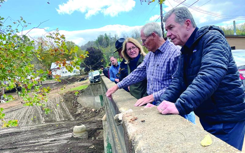 MNJ photo/Mariel Williams.  Mayor Charles E. Vines explains the flood damage in Bakersville to Federal Emergency Management Agency Administrator Deanne Criswell, left, and Gov. Roy Cooper, right.
