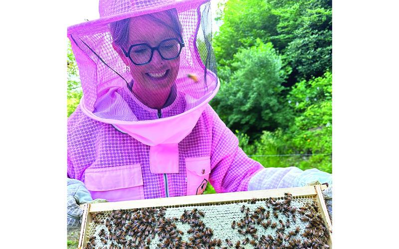 Submitted photos.  Kim Gunter harvests honey from her beehives. Gunter, a first-time beekeeper, lost all her hives to September flooding. Her last jar of honey will be one of several featured in a blind taste test contest today in Burnsville.