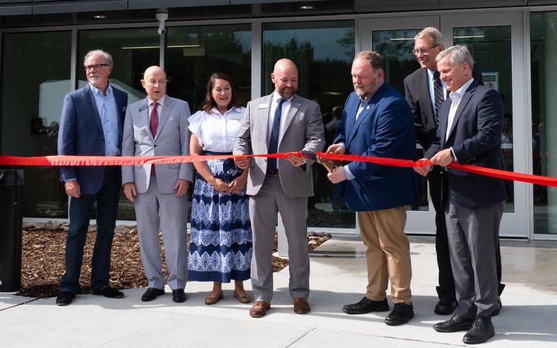 MNJ Photos/Sarah Atkins.  Sen. Ralph Hise cuts the ribbon during the grand opening of the new YMCA facility. From left are Van Phillips, John Blackburn, Sarah Grimes, Williams YMCA CEO Trey Oakley, Hise, Mayland Community College President John Boyd and N.C. Gov. Josh Stein.