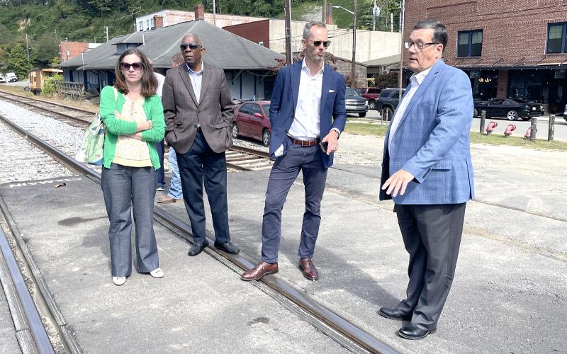 MNJ Photo/Mariel Williams.  Bill Slagle, executive director of the Mitchell County Economic Development Commission, explains flood devastation in downtown Spruce Pine to North Carolina Secretary of Commerce Lee Lilley, center right.