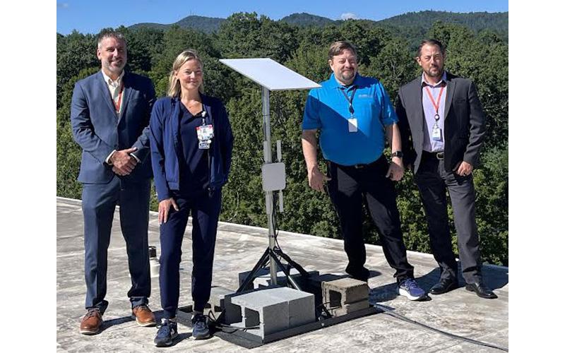 Submitted photo.  Sean Morrison, Carrie James, Joe Seely and AJ Shipman show off the newly-installed BlueNet communications dish on the roof of Blue Ridge Regional Hospital.