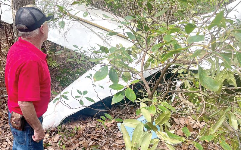 MNJ Photo/Mariel Williams.  Mitchell County resident Alex Glover examines the wreckage of a glider that crashed overlooking McKinney Mine Road recently.