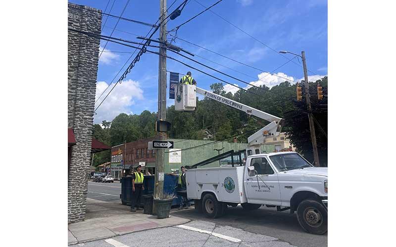 MNJ Photo/Mariel Williams - Spruce Pine staffers put up banners in honor of the 250th United States Independence Day.
