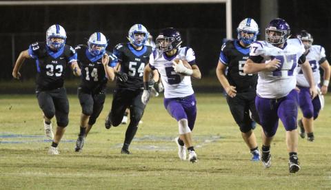 Mitchell junior Ty Pitman (No 5) breaks away from Polk defenders behind lead blocker and senior Lathan Adkinson (No. 77) Friday, Nov. 1, during the Mountaineers’ 33-0 win over the Polk Wolverines in Columbus. Pitman caught one pass for 15 yards and a touchdown in the game. (MNJ/Brandon Roberts)