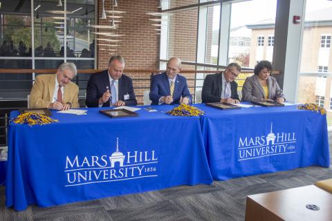The Local Lion Promise guarantees scholarships covering at least half the price of tuition for students from Buncombe, Madison, Mitchell and Yancey counties. Pictured, from left, are school superintendents Tony Baldwin, of Buncombe County, and Will Hoffman, of Madison County; Mars Hill University President Tony Floyd; and school superintendents Chad Calhoun, of Mitchell County, and Kathy Amos, of Yancey County. (Submitted)