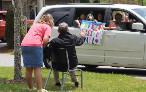 Mitchell House Resident Waves at Family During Parade