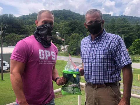 Greenlee Primary Principal Jason Hall and Gouge Elementary Principal Colby Calhoun hold one of their newly-created playground bags which are designed to allow students to play safaly amid the pandemic. (Photo by Mitchell County Schools)