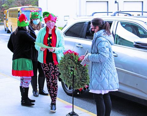 Alli McClellan of the Creative Clovers 4-H Club smiles under her face covering as she takes a letter to Santa delivered by car at Bowman Middle School on Saturday, Dec. 5. In addition to processing Santa letters and other duties, club members also sold Christmas ‘Neath the Roan T-shirts. (MNJ photo/Cory Spiers)