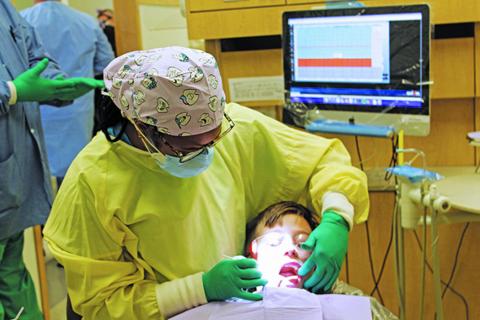 Vonstrika Jones gives 8-year-old Alexei Yoder a dental check with a mirror on Friday, Feb. 5. Jones and the rest of the staff at the East Carolina University School of Dental Medicine Community Service Learning Center of Spruce Pine performed free services during the annual Give Kids a Smile event. (MNJ photo/Cory Spiers)