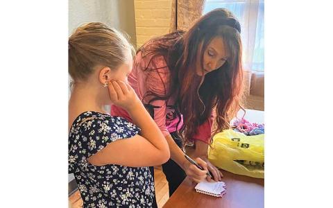 Photo submitted - Shawn Burleson and Amaya Stowe check off the list of items being placed in a Bag of Hope.