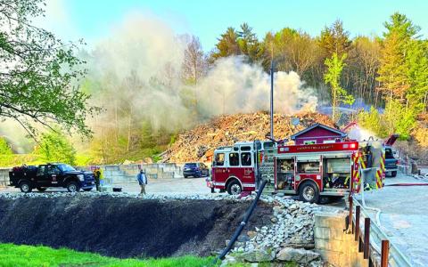 Photos/Mitchell County Government. Fire crews at work in Grassy Creek, where a mulch fire was successfully contained after a joint effort.