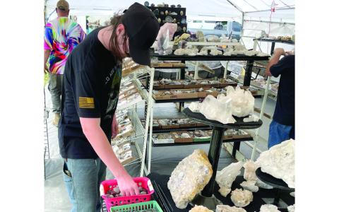 MNJ Photo/Mariel Williams. Schuyler Daugherty, 18, of Asheboro looks through a bin of polished stones at the Grassy Creek Mineral & Gem Show. Daugherty was in town this past weekend visiting family. “I love coming here,” he said. “Now that I have my own money I plan on spending more than usual.”
