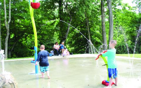 MNJ Photo/Sarah Atkins. Samuel Clark, 6, and his brother James Clark, 8, enjoy playing at the splash pad at Riverside Park in Spruce Pine.