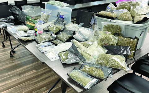 MNJ photo/Mariel Williams. The dried marijuana products on this table added up to approximately 23 pounds and $70,000. Some of the bags came labeled with the names of specific varieties, such as “Trailer Trash” or “Apple Pie.”