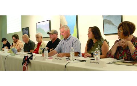 MNJ Photo/Mariel Williams.  Moderator Spencer Bost reads a question for participants in the arts and culture candidate forum at Toe River Arts. From left are moderator Nealy Andrews, Bost, and candidates Dale Blevins, Ron McKinney, Lee Ellis, Bill Hoag, Harley Masters and Jan Hamilton. 