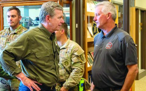 Submitted photo/ Governor’s office.  N.C. Governor Roy Cooper talks with Spruce Pine Assistant Fire Chief Bill Hoag. On Tuesday, Oct.8, Governor Cooper traveled to Spruce Pine and was joined by FEMA Administrator Deanne Criswell, Federal Highway Administration Acting Administrator Kristin White and other state and federal officials to assess storm damage, thank volunteers and speak with people impacted by Hurricane Helene.