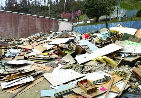 MNJ photo/Mariel Williams.  Unsorted debris fills the parking lot next to the old Carolina Theater on Lower Street (Locust Street) in Spruce Pine. In order to get picked up and properly disposed of, flood debris is supposed to be sorted into three categories: wood/tree waste, construction debris and white goods (appliances). Those piles should be stacked on the right-of-way of state and town roads.