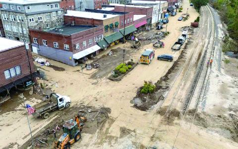Photo / Steve Exum / Getty Images via Grist.  Residents and business owners in Spruce Pine haul away some of the debris and mud that inundated downtown. 