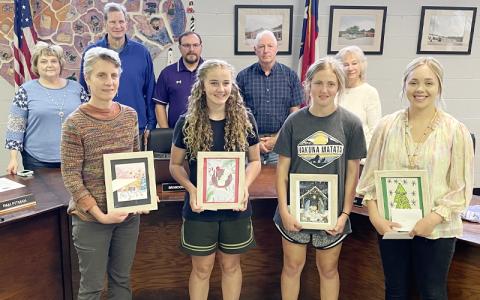 MNJ Photo/Mariel Williams.  Winners of the annual Christmas card competition pose with the Mitchell County Schools Board of Education. From left are art teacher Melissa Cadell, middle school winner Ella Calhoun, high school winner Sadie Calhoun and art teacher Carley Roark.