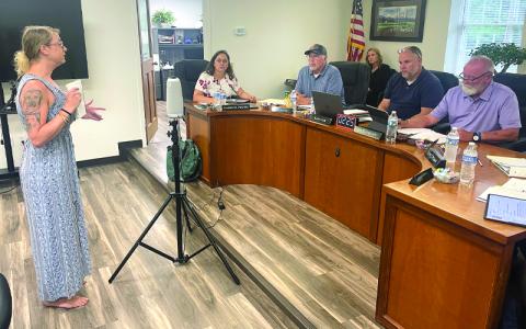 MNJ Photo/Mariel Williams.  Page Cash, a disaster-recovery volunteer from Virginia, speaks to the Mitchell County Board of Commissioners.